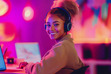 Poster - woman wearing headphones and smiling while sitting at a desk with a laptop. concept of relaxation an