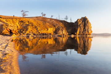 Wall Mural - Scenic landscape of Baikal Lake on May evening. Coastal cliffs of Olkhon Island in sunset light. Last ice floes float on water. Tourists take pictures of beautiful view. Spring travels and outdoors 