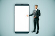© Who is Danny - Businessman presenting a giant smartphone with a blank white screen.