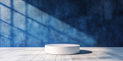Poster - Minimalist display pedestal against textured blue wall with dramatic shadows