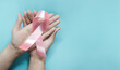 © LAONG - Woman hand holding pink ribbon breast cancer awareness. Cancer Support. Healthcare and medicine beauty concept. Examination Reminder. Spread the Pink October campaign