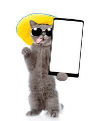 Aufkleber - Happy cat wearing sunglasses and summer hat standing on hind legs and showing big smartphone with white blank screen. Empty space for text. isolated on white background