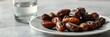 © Kseniia - Fresh dates and water, healthy mood, served on plate with glass of water on table
