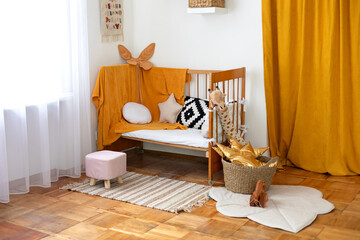 Wall Mural - Cozy Scandinavian baby room: wooden crib with bedding, pillows, basket with toys, pouf and carpet on floor. Modern interior design of a child bedroom. Kindergarten. Baby accessories on shelves mockup.