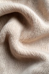 Poster - A tightly woven beige knitted fabric with soft folds creates an inviting texture, partially cast in deep black shadow, enhancing its sophisticated appearance and depth