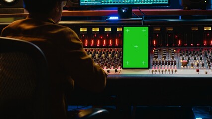 Aufkleber - African american audio technician mixing and editing tracks with greenscreen on tablet, working in professional post production studio. Producer creating new tunes for his album. Camera A.