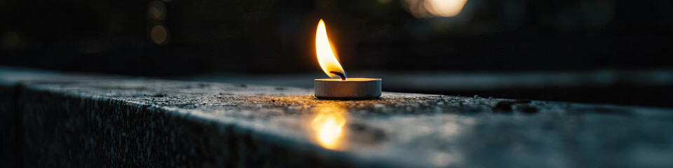 Wall Mural - Lit Tea Light Candle on Stone Surface