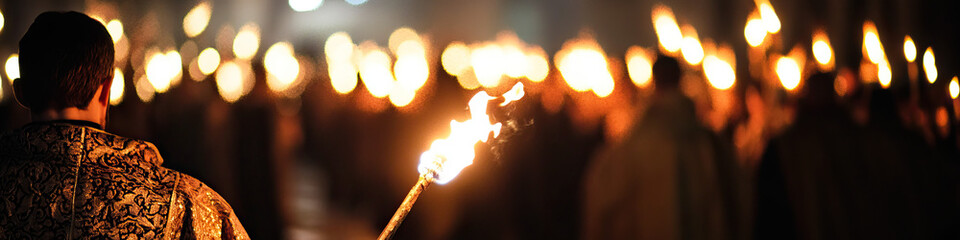 Wall Mural - Person Holding Torch in Crowd with Torches at Night