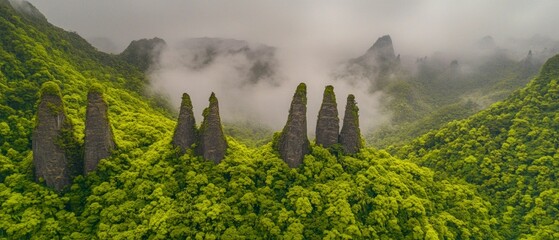 Canvas Print - Lush Green Mountain Landscape with Unique Rock Formations and Misty Clouds