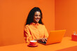 © Jacob Lund - Monochromatic office concept with smiling African-American woman working on laptop with cup of coffee
