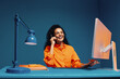 © Jacob Lund - Customer service agent in office using headset and computer with color blocking bright clothes