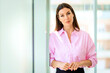 © gzorgz - Caucasian businesswoman standing in a modern office by the window