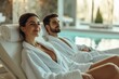 © Di Studio - beautiful woman and handsome man in bathrobes relaxing in modern spa near swimming pool