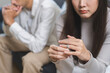 © KMPZZZ - Stressed asian young couple man, woman quarrel on couch, relationship in trouble. Wife hand holding wedding ring in disappointment and upset her husband, which may lead to divorce. Problem of family.