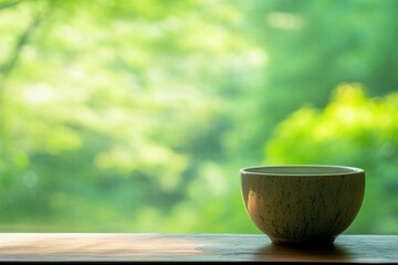 Aufkleber - tranquil tea bowl resting on wooden table with lush greenery in the background during daylight