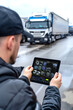 © Degimages - Warehouse exterior shows experienced truck driver operating tablet for detailed route mapping and scheduling