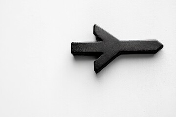 Poster - Decorative black arrow symbol on a white surface indicating direction and purpose in a minimalist design