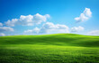 © Taftizan - Vibrant Green Rolling Hills Under a Clear Blue Sky with White Clouds