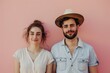 © Markus Schröder - Portrait of a tender caucasian couple in their 20s wearing a rugged cowboy hat in front of solid pastel color wall