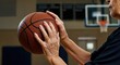 © Tati - Elderly person holding basketball, indoor court, focus on hands