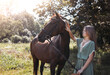 © ADDICTIVE STOCK - Young girl and horse in serene countryside setting under sunlight