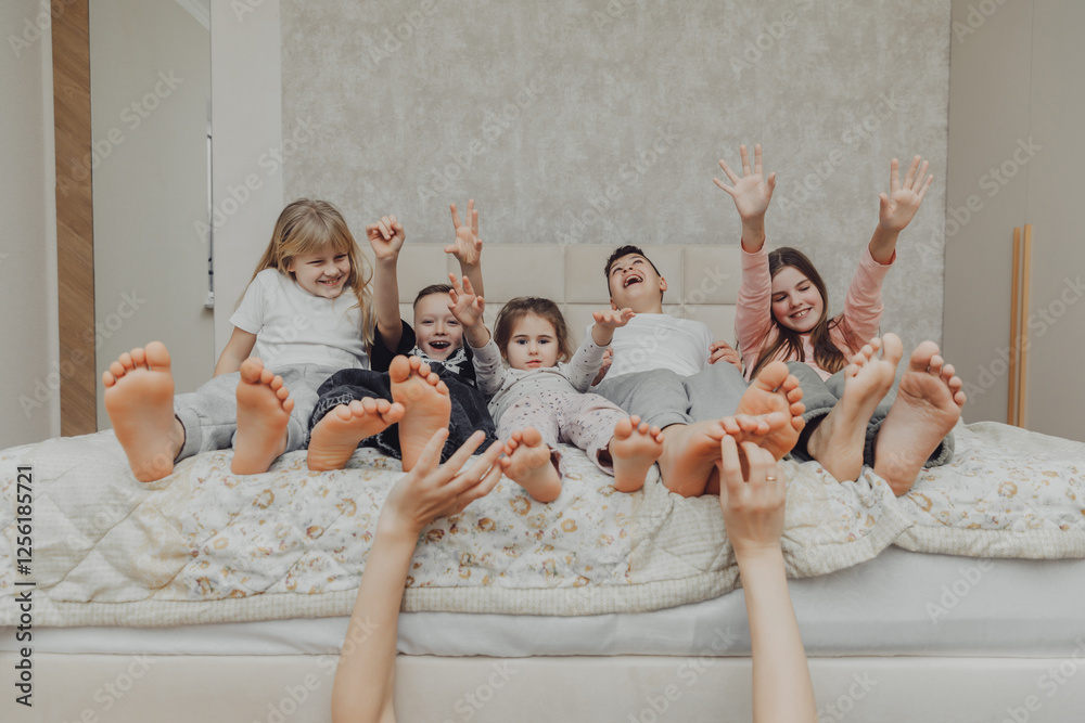 Mom tickles the feet of her little children. Mom and children have fun