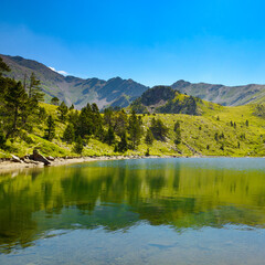 Wall Mural - Picturesque small lake high in the mountains against the backdrop of sky.