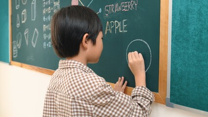 Poster - asian boy drawing picture to express and develop imagination while standing at blackboard in classro