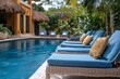 © Michael - Comfortable sunbeds with cushions invite guests to relax and unwind by the tranquil blue swimming pool of a luxury resort