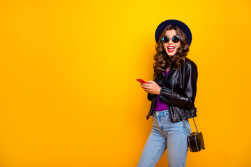 Canvas Print - Portrait of shocked funny funky lady with curl hairstyle use her mobile phone read feednes in blogs scream wow omg wear black outfit denim jeans isolated over yellow color background