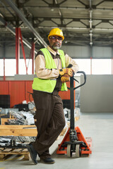 Aufkleber - Confident mature male engineer standing by pallet truck and looking at camera while standing against packed spare parts