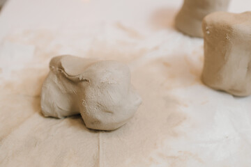 Fototapete - Potter is sculpting wet clay for ceramics products. Hands of a female potter making ceramic clay product on the table in the pottery workshop.