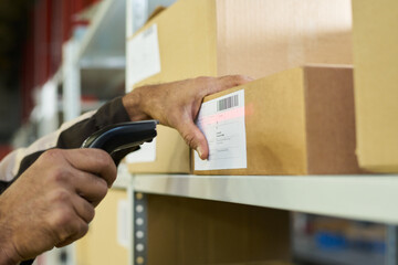 Aufkleber - Hand of modern engineer scanning barcodes on stickers on packed cardboard boxes standing on shelf in warehouse