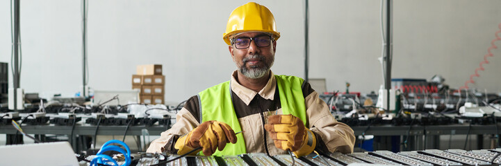 Leinwandbilder - Header of confident mature male worker of factory wearing protective helmet and safety jacket looking at camera