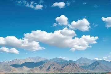 Fototapete - Majestic mountain range under soft clouds and blue sky with space for text. Generative AI