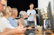 © JackF - Middle-aged female instructor teaching computer skills to old students during IT classes
