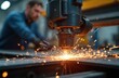 © miss irine - Selective focus on modern tech laser plasma cutting of metal at metalworking factory. Sparks from laser machine. Metalwork manufacture with worker on background. Automated automobile industry