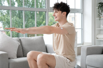 Wall Mural - Diabetic young man with glucose sensor training at home