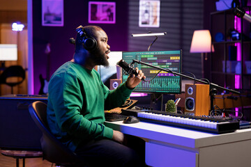 Poster - Artist composer recording a new track on his home studio microphone, editing his song with professional gear. Adjusting volume levels and adding sound effects, mix and master.