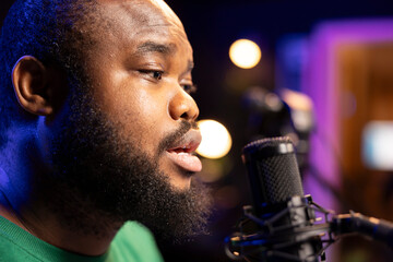 Poster - Songwriter singing a new song on his microphone to produce new tracks for music industry, home studio gear. Artist records his voice and own lyrics to edit in mixing and mastering session. Close up.