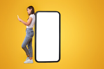 Aufkleber - Great App. Happy Lady Leaning On Big Smartphone With Blank White Screen And Using Cell Phone, Cheerful Female Chatting On Social Media, Standing On Orange Background, Mock Up Image, Full Body Length