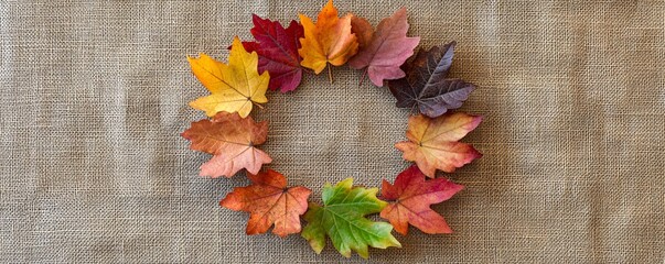 Aufkleber - Colorful autumn maple leaves arranged in a circle on a burlap cloth, creating a rustic and natural fall backdrop