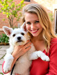 © Megan - Young White Caucasian woman holds her small white outbred adopted dog in the courtyard