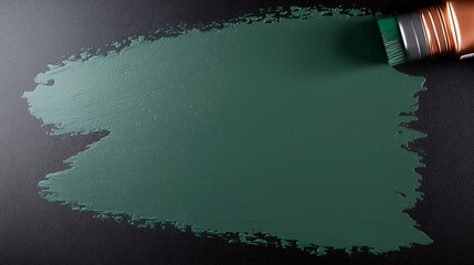 Brush applying dark green paint on a textured black surface, creating an artistic background