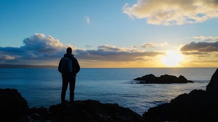 Silhouette of a person standing on a rocky coast at sunset enjoying nature and serenity by the ocean : Generative AI