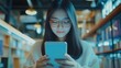 © Julia - Female Student using smartphone to check personal finances