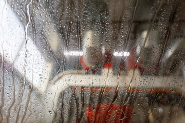 Wall Mural - A blurry image of a car with raindrops on the windshield