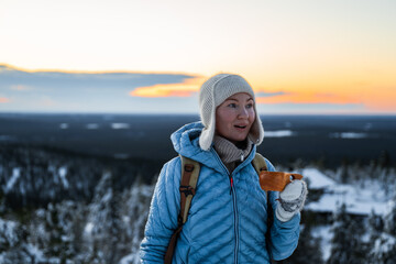 Wall Mural - woman on top of a hill in a Finnish national park drinks a hot drink