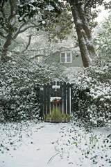 Wall Mural - Snow-covered garden gate leading to a cozy home in a rare winter scene