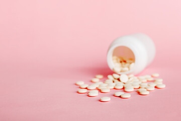 Wall Mural - Medicine bottle and white pills spilled on a light background. Medicines and prescription pills flat lay background. White medical pills and tablets spilling out of a drug bottle